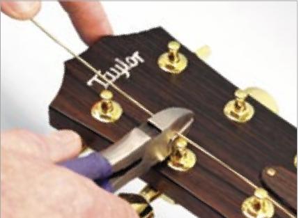4. 先换6弦。穿过琴头旋钮孔后，在5弦的旋钮处把多余部分剪掉，也就是留出3厘米左右。